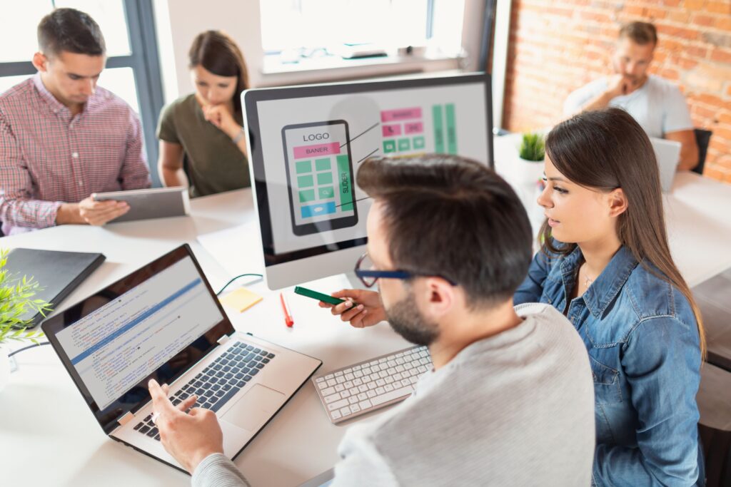 designers drawing and working on a website on PC